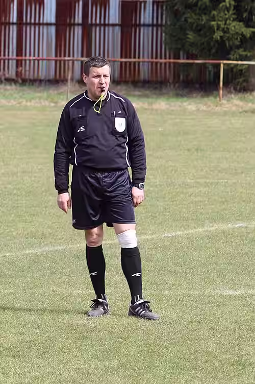 What Does Advantage Mean in Soccer?
Soccer referee standing on the field and blowing a whistle during a match